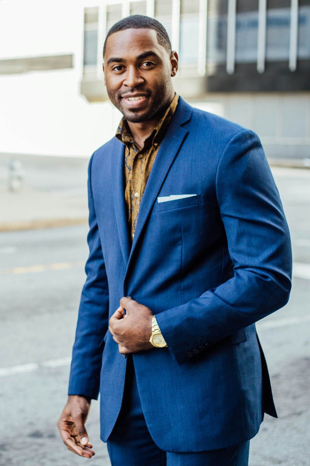 A FPFoCo financial planning client, a young professional in a suit, stands before a building