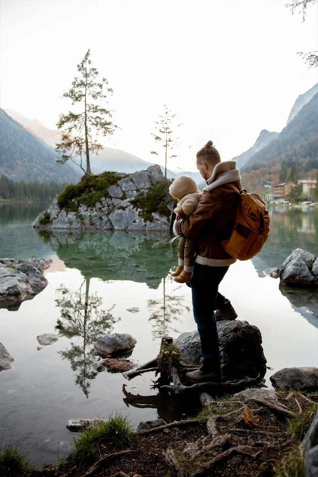 A young father hiking near a lake with his child in Fort Collins, Colorado.